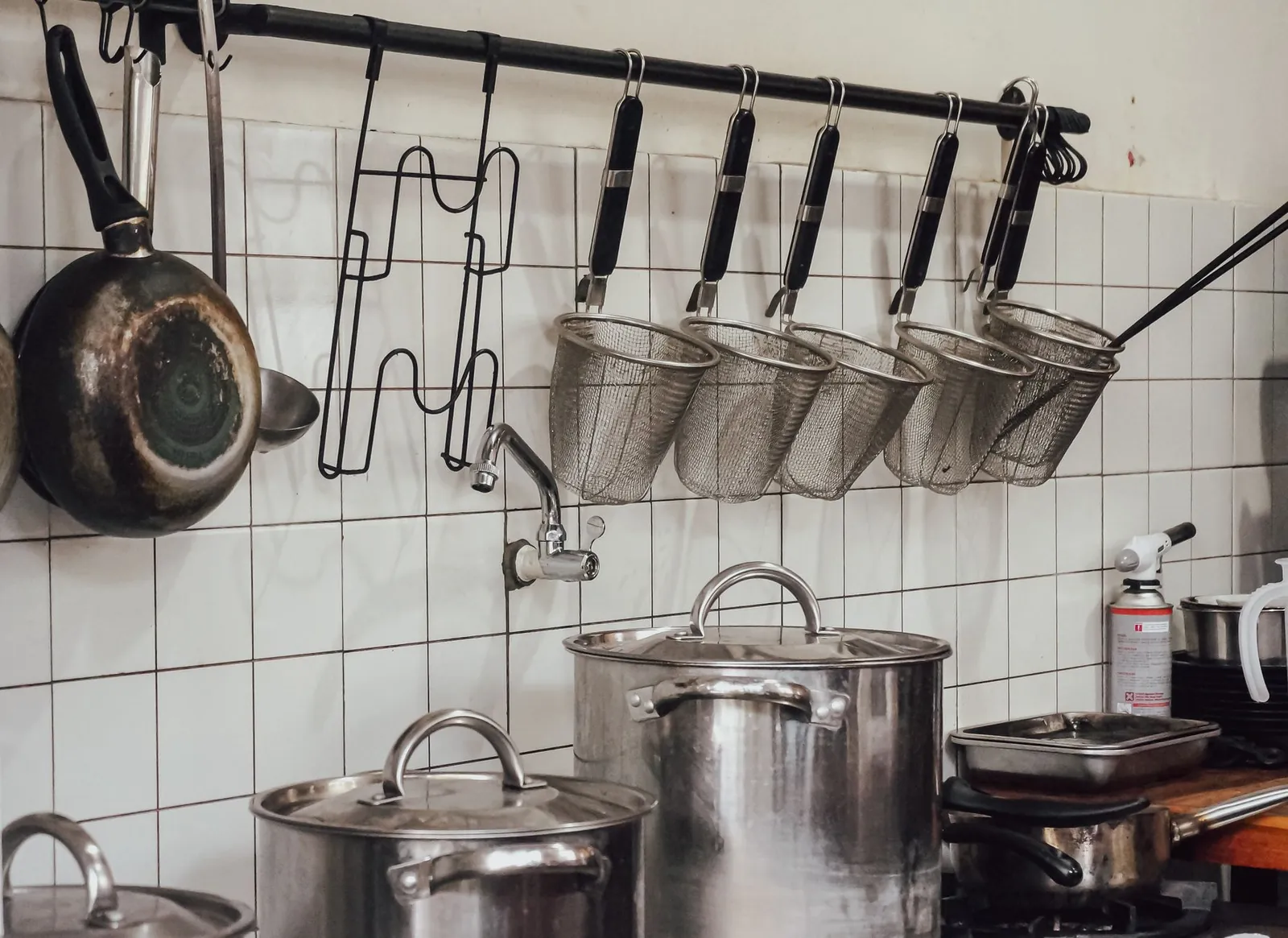 Ollas de acero inoxidable sobre la estufa de una cocina industrial