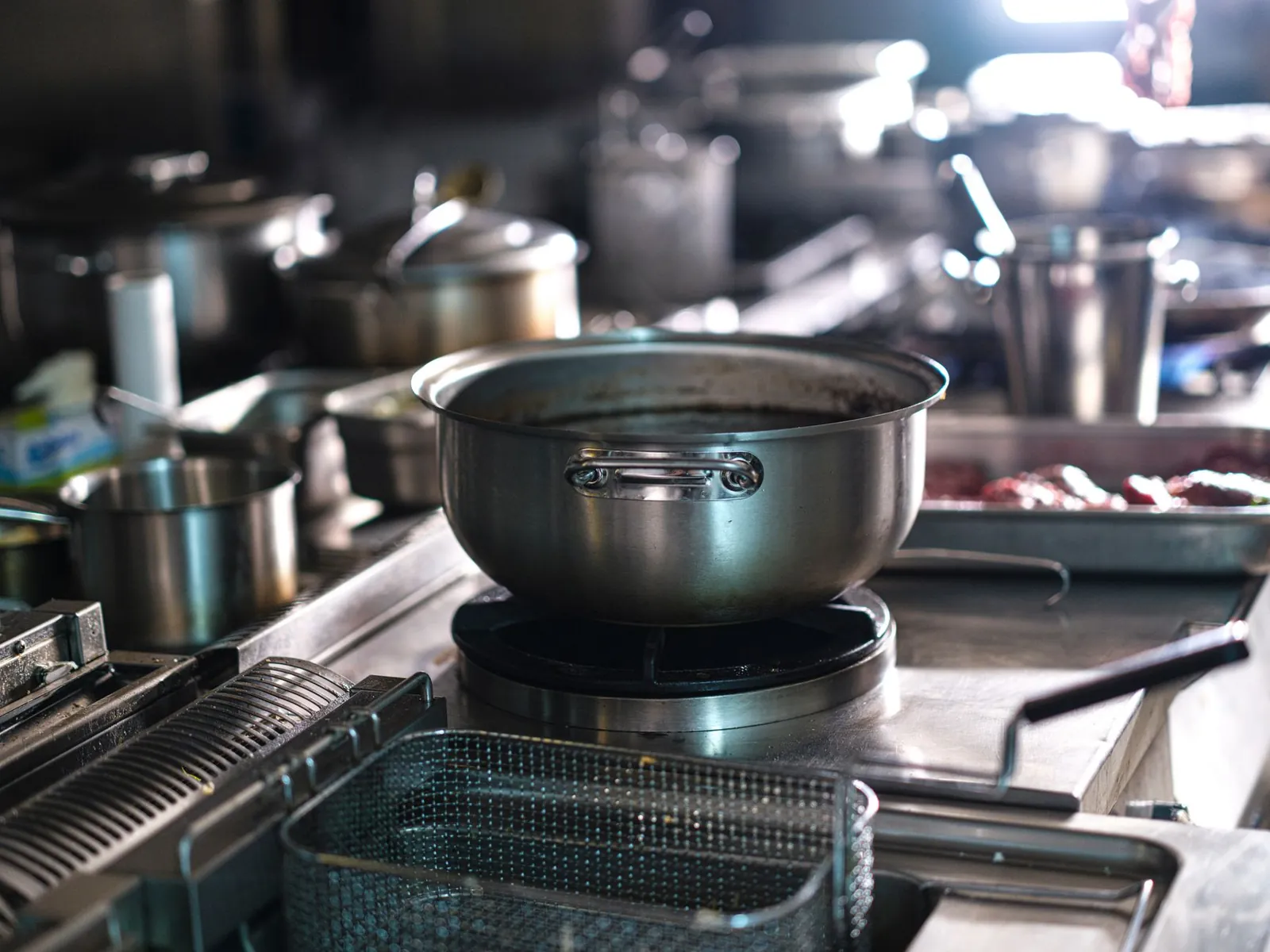 Estufa de cocina industrial con olla al fuego y freidoras