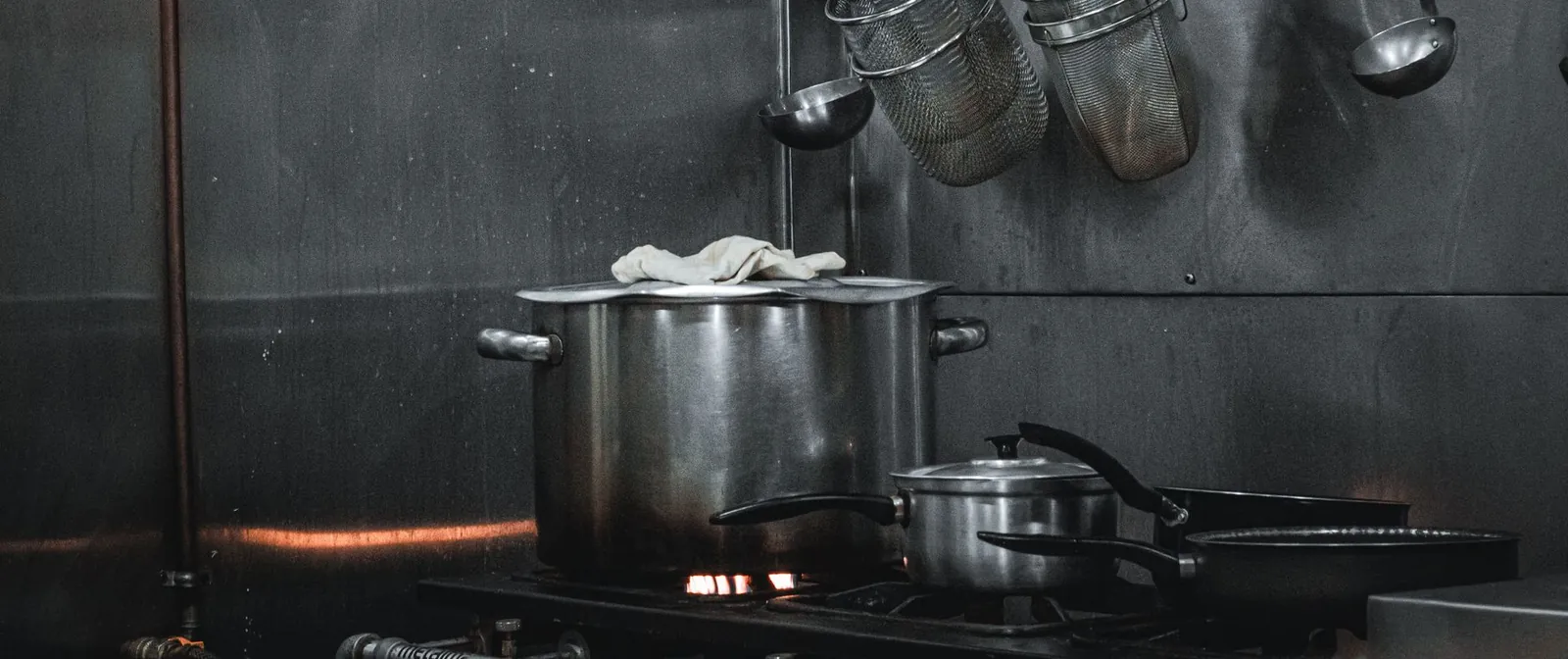 Ollas de acero inoxidable sobre la estufa de una cocina industrial