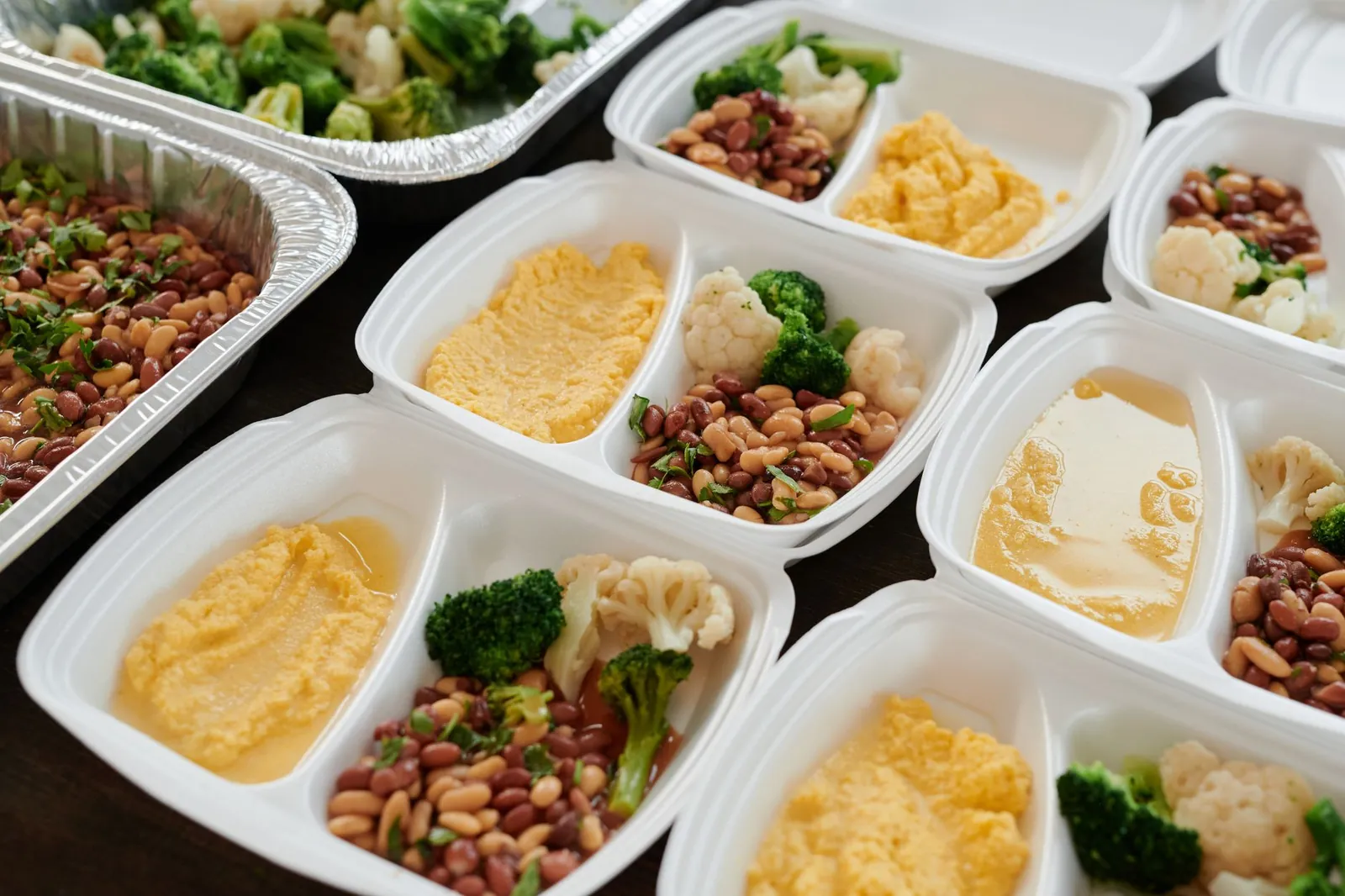 Comidas servidas en charolas divididas con frijoles, puré y verduras